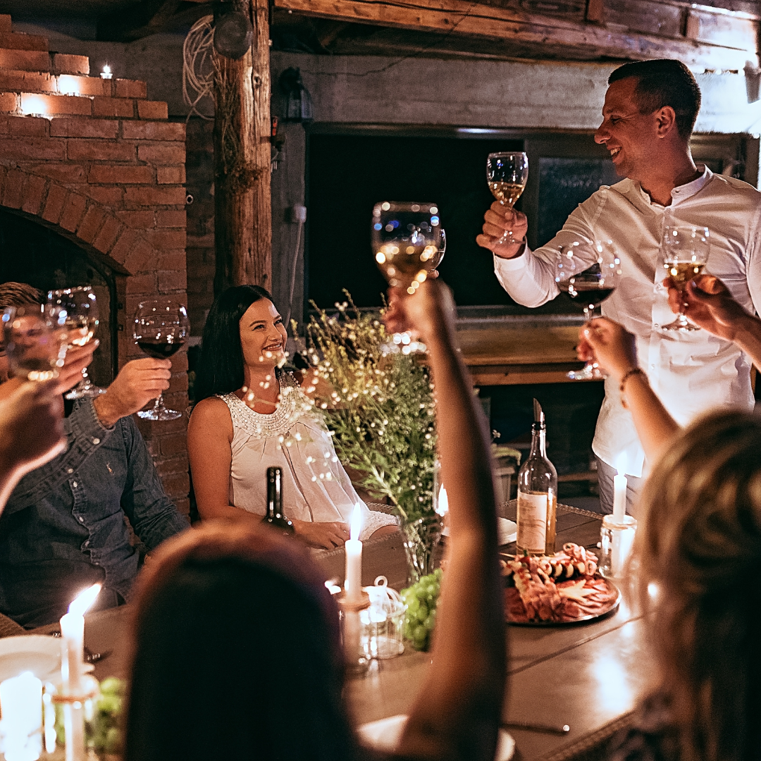 Friends enjoying dinner together, sharing food and laughter — the essence of hosting essentials at home.