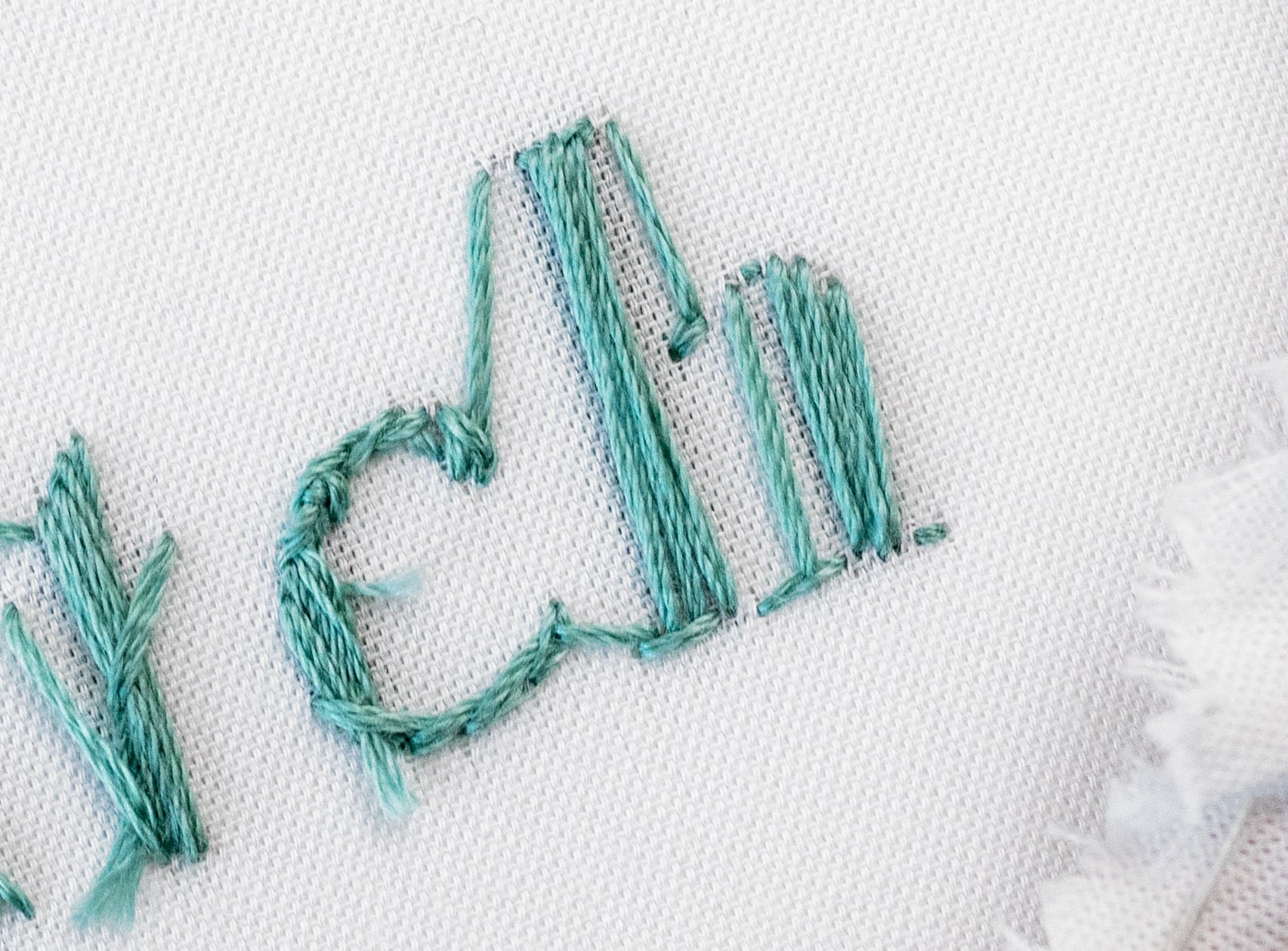 The word 'satin stitch' is stitched using satin stitch from behind.
