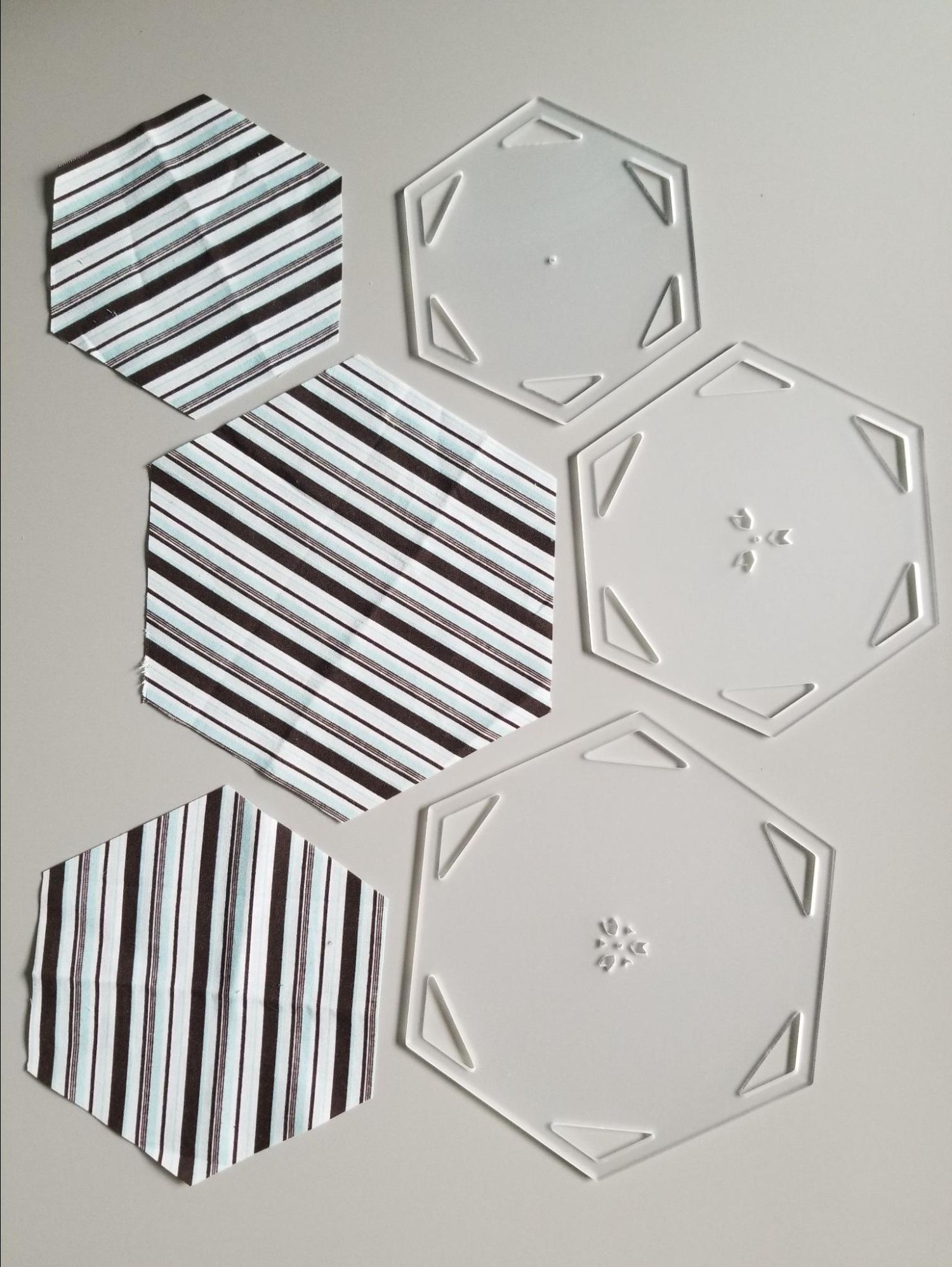 Set of large fabric hexagons that were made by rotary cutting around a hexagon quilt template.