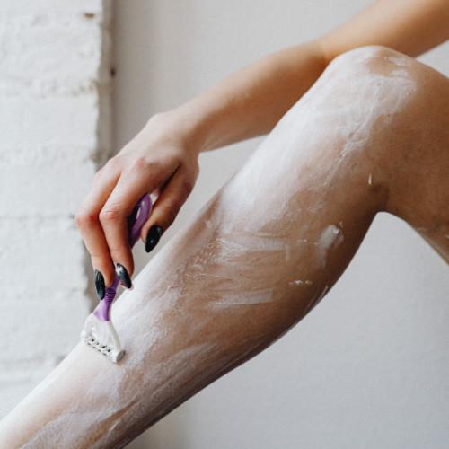 close-up of woman shaving her leg.