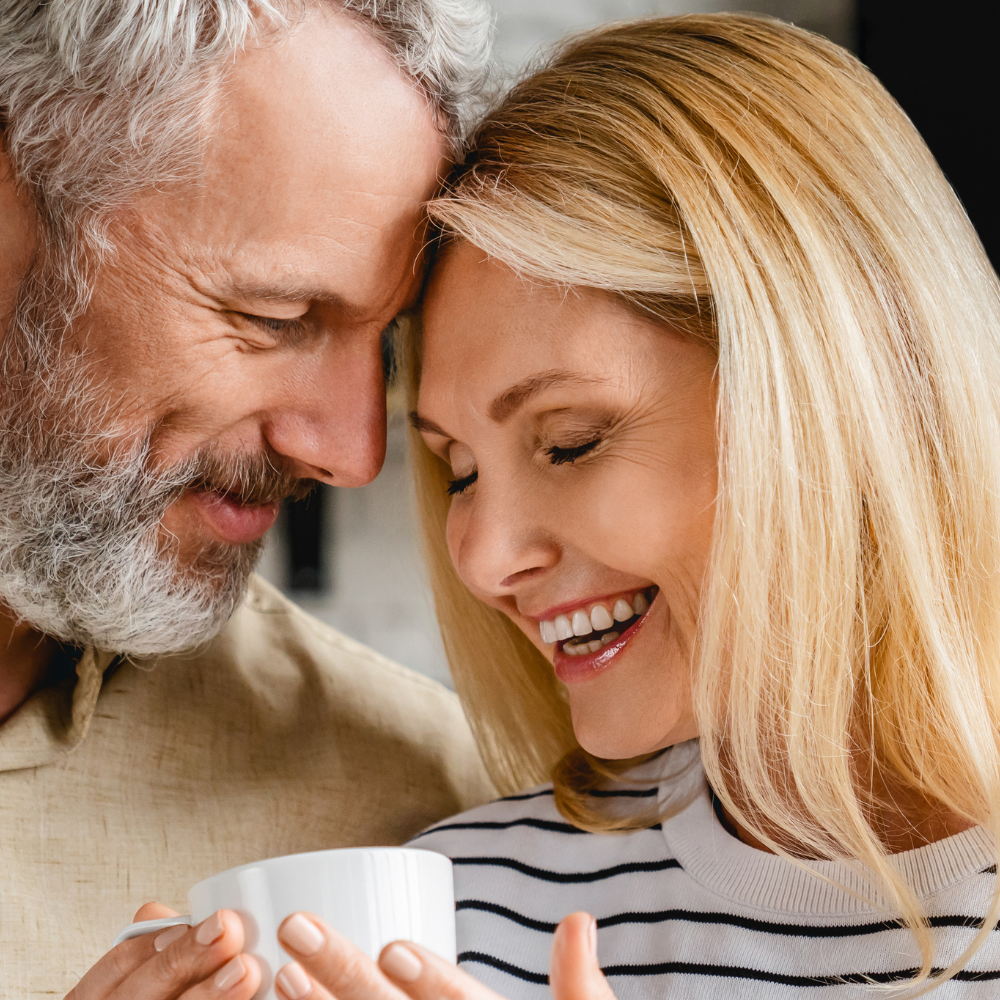 man handing smiling woman cup of coffee