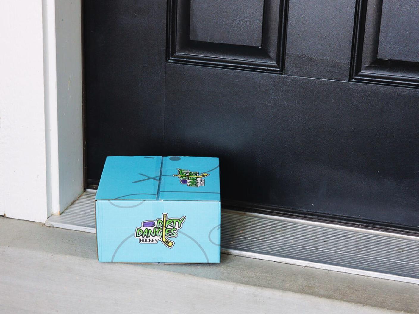 a blue dirty dangles build a box subscription box on a door step. Dirty dangles hockey