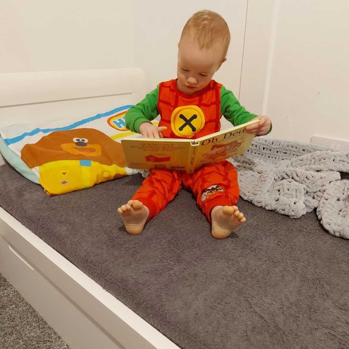Boy reading a book on washable bed mat PeapodMat