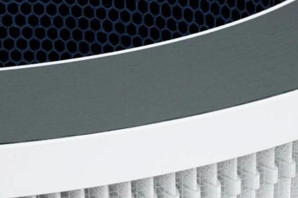 Close-up of an air purifier filter with layers of honeycomb and HEPA structures.