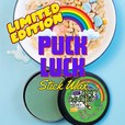 A tin of dirty dangles puck luck st patricks day stick wax on a blue background with a bow of marshmallow cereal and a rainbow. Limited edition puck luck stick wax shop now