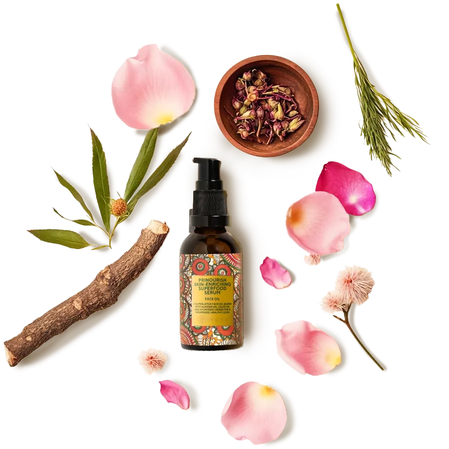 A bottle of prenourish surrounded by aromatic ingredients like rose and nut grass