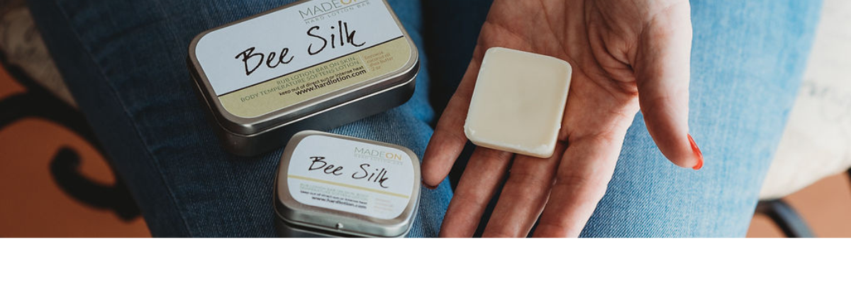 hand holding pocket size beesilk lotion bar with tins on lap