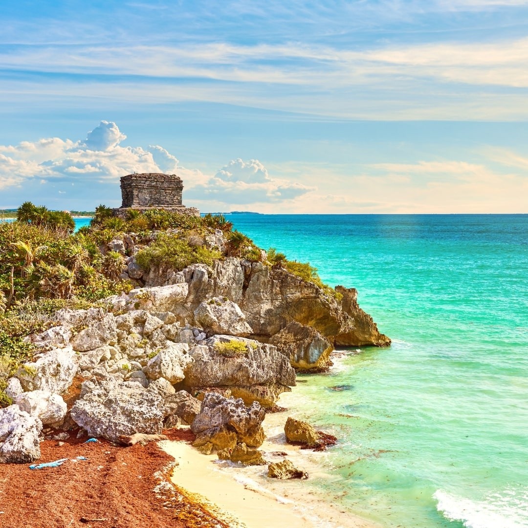 A view of a shore in Tulum bordered with boulders
