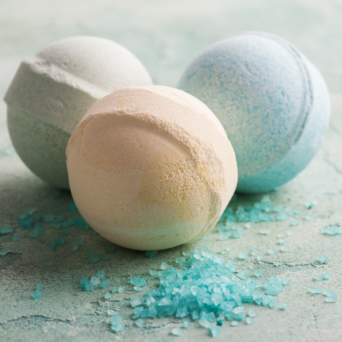 3 different bath bombs, white, light brown, and light blue.