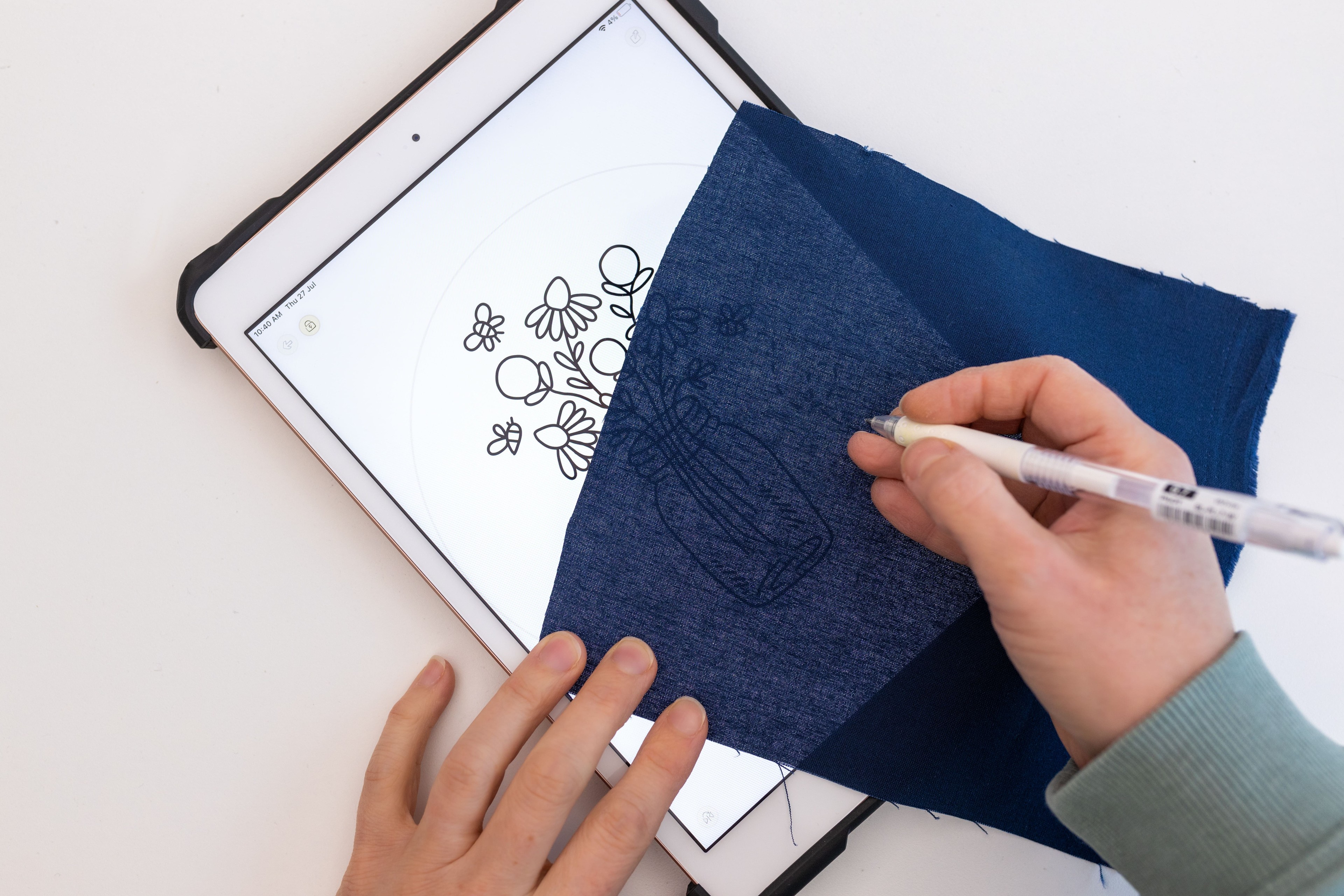 A piece of fabric is placed over an Ipad pattern of 'Floral vase' with a white background.