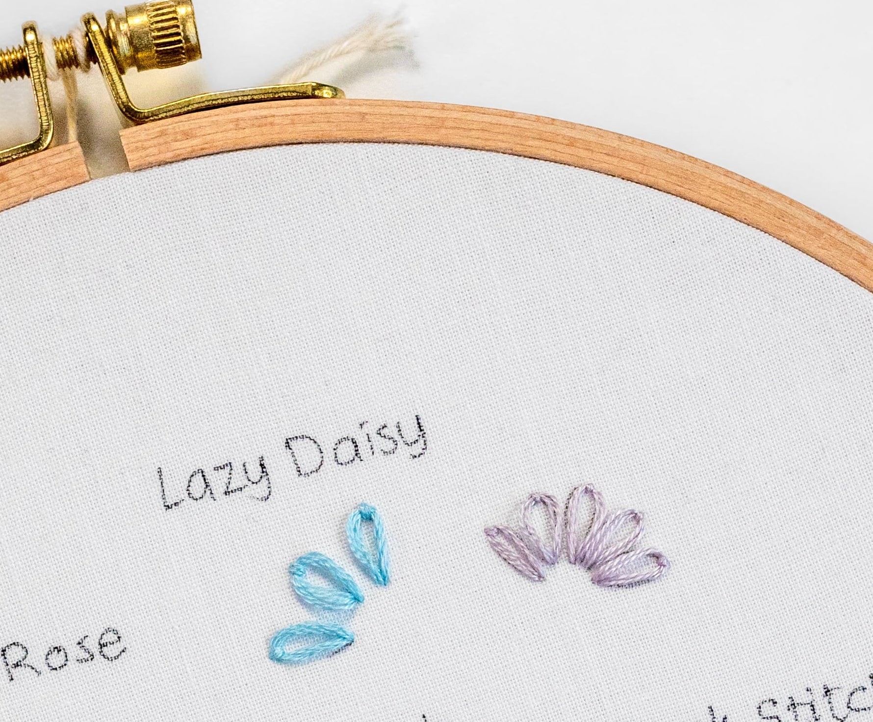Lazy Daisy stitches are put on an embroidery sampler