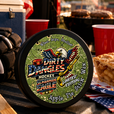 A tin of dirty dangles screamin eagle 4th of july stick wax on a truck tailgate with apple pie and american flags
