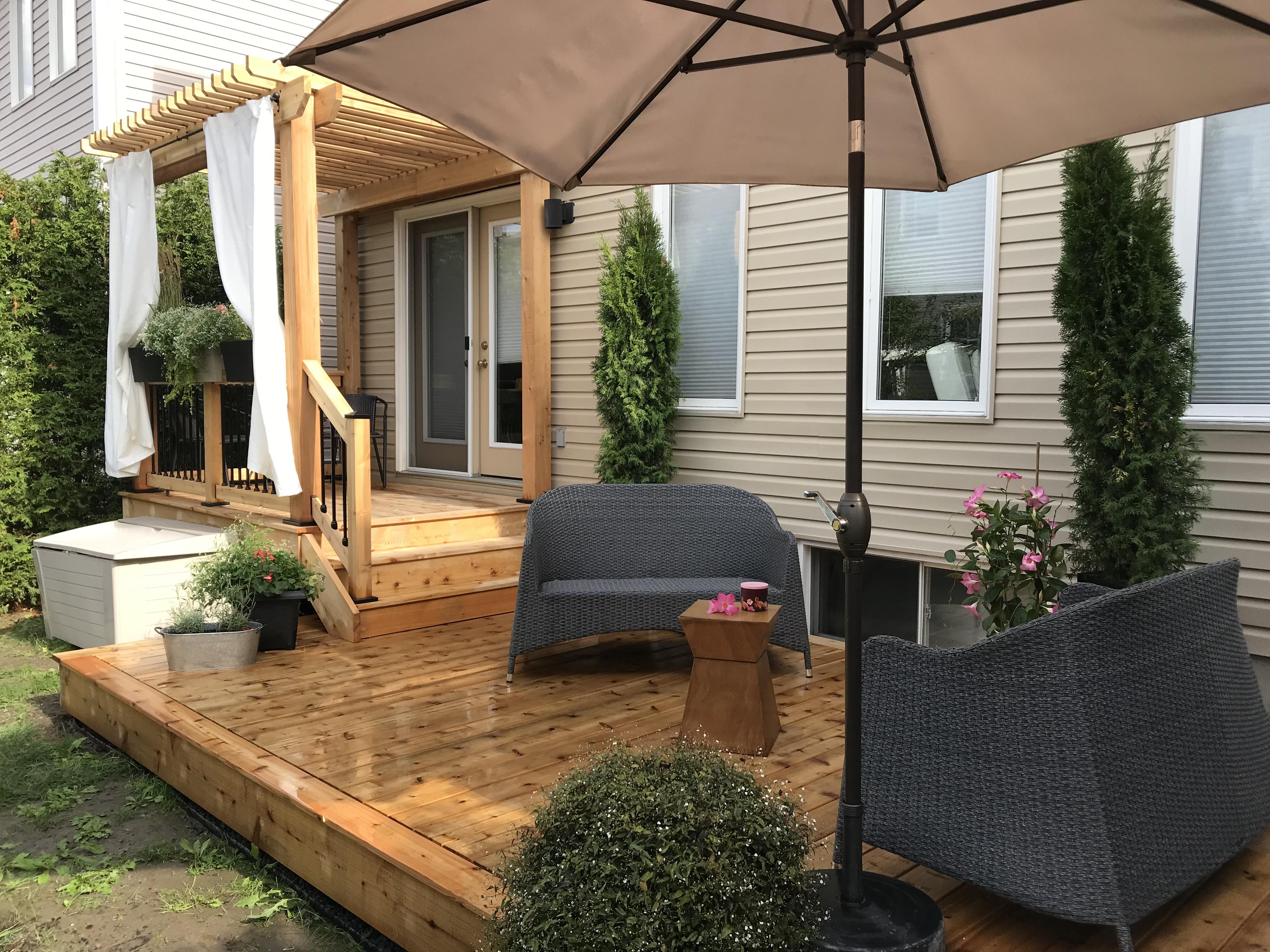 photo depicting a beautiful wood stained deck with stairs leading up to a wooden pergola