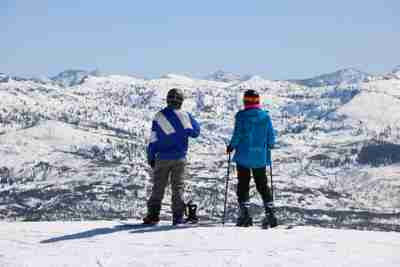 Two people standing on top of a snowy mountain