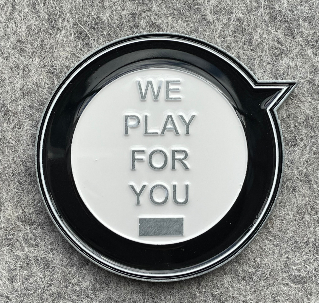 a custom sports challenge coin with black, and white enamel colors and sign we play for you