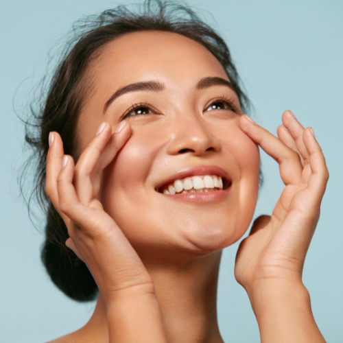 Senior woman smiling and showing off healthy, clear skin.