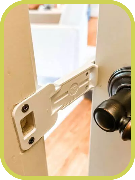 Close up of The Door Buddy door prop mounted between the door and door frame. The image highlights the patented design made in the USA that holds the door slightly open for cats while helping keep dogs out.