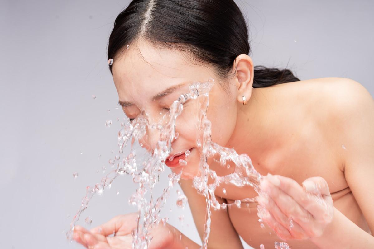 woman splashing water on her face.