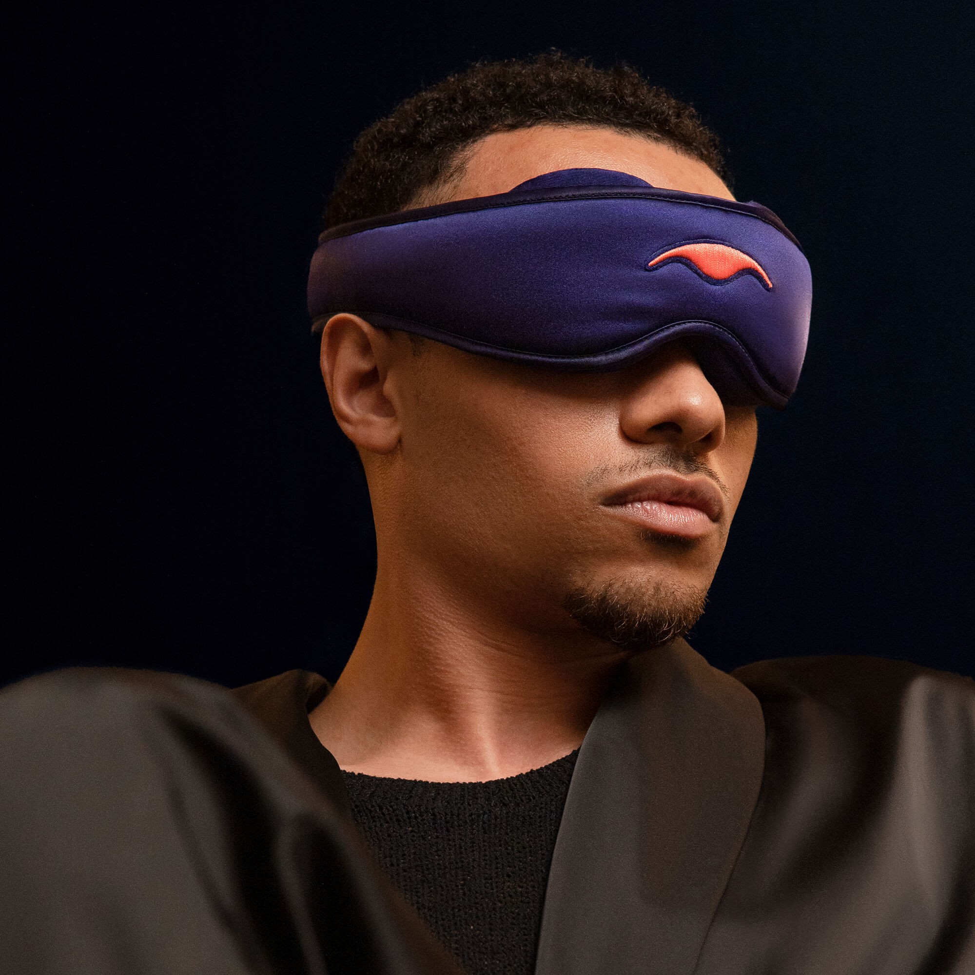 A man wearing the best silk sleep mask with eye cups.