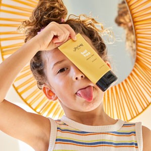 Girl holding Best Face Gel Cleanser up to face and sticking out her tongue