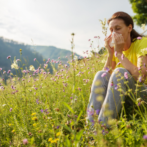Woman in flowers with allergies