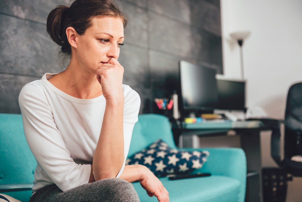 woman sitting sad on couch