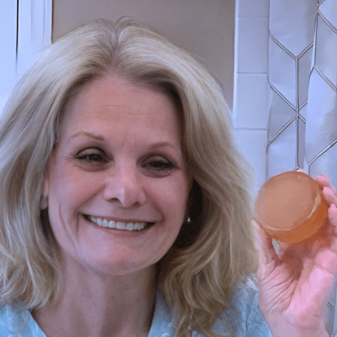 Smiling woman holding Mirai Clinical persimmon soap for Nonenal odor.