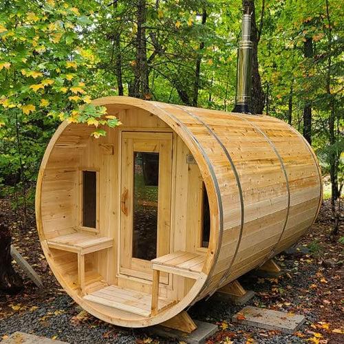 a barrel sauna in a foresto or outdoor area surrounded with trees