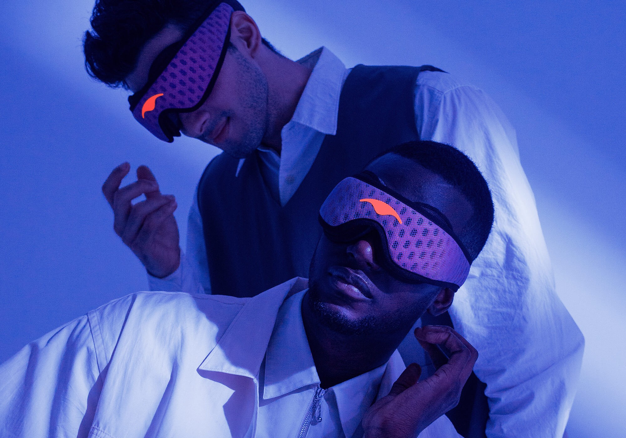 Two men wearing blue mesh sleep masks from Manta Sleep.