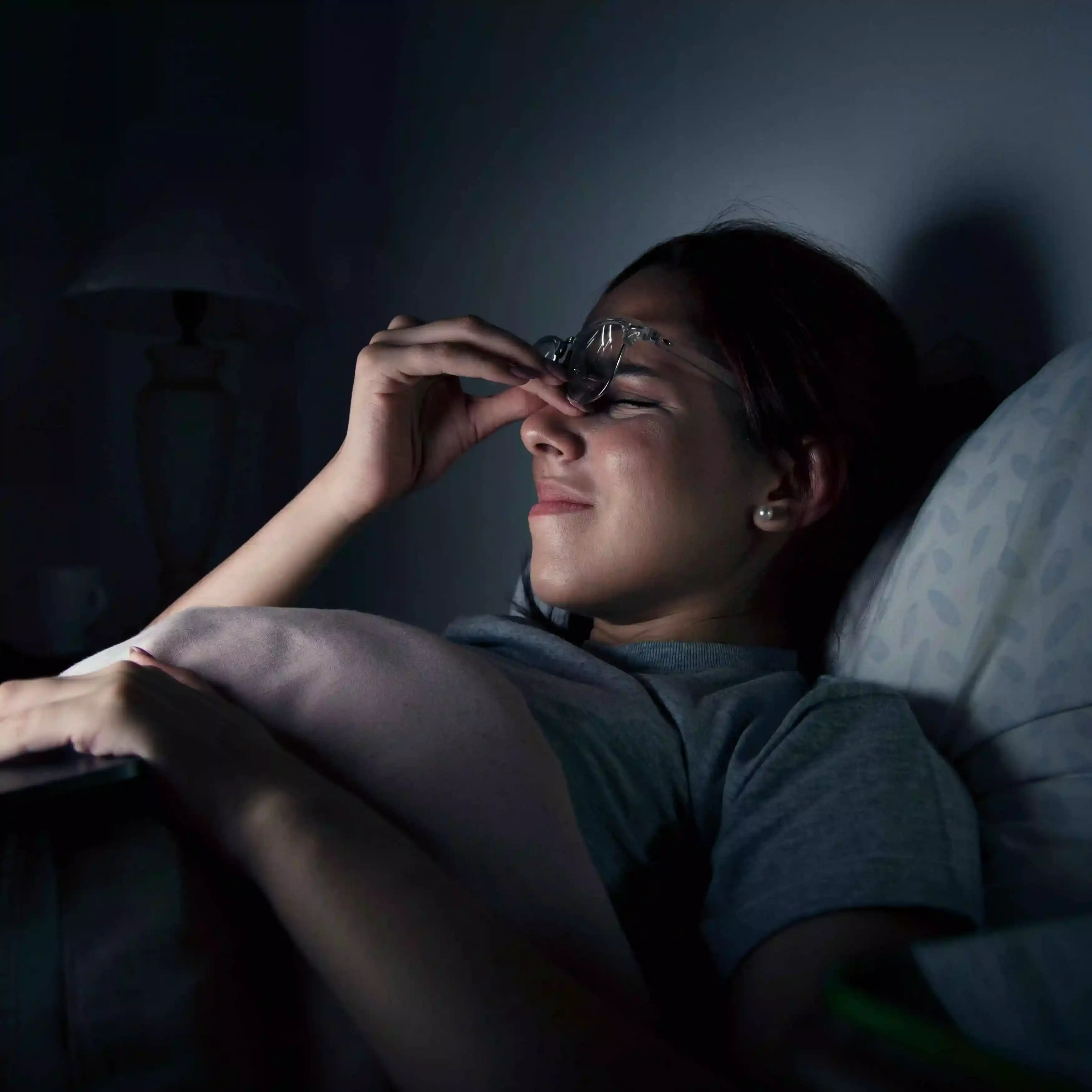 A lady struggling to read in the dark