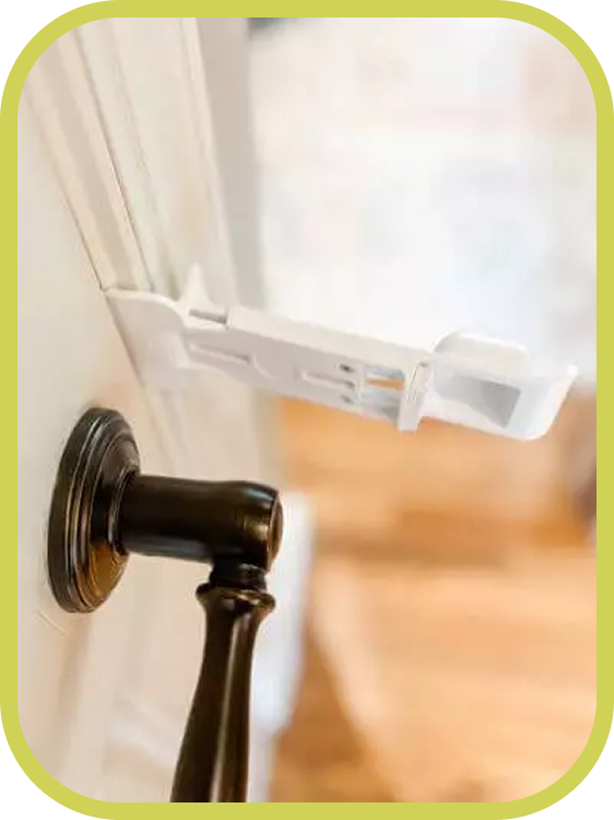 The Door Buddy door prop is shown installed on a door handle while the door closes against it. The design allows the door to be fully closed without removing the door prop.