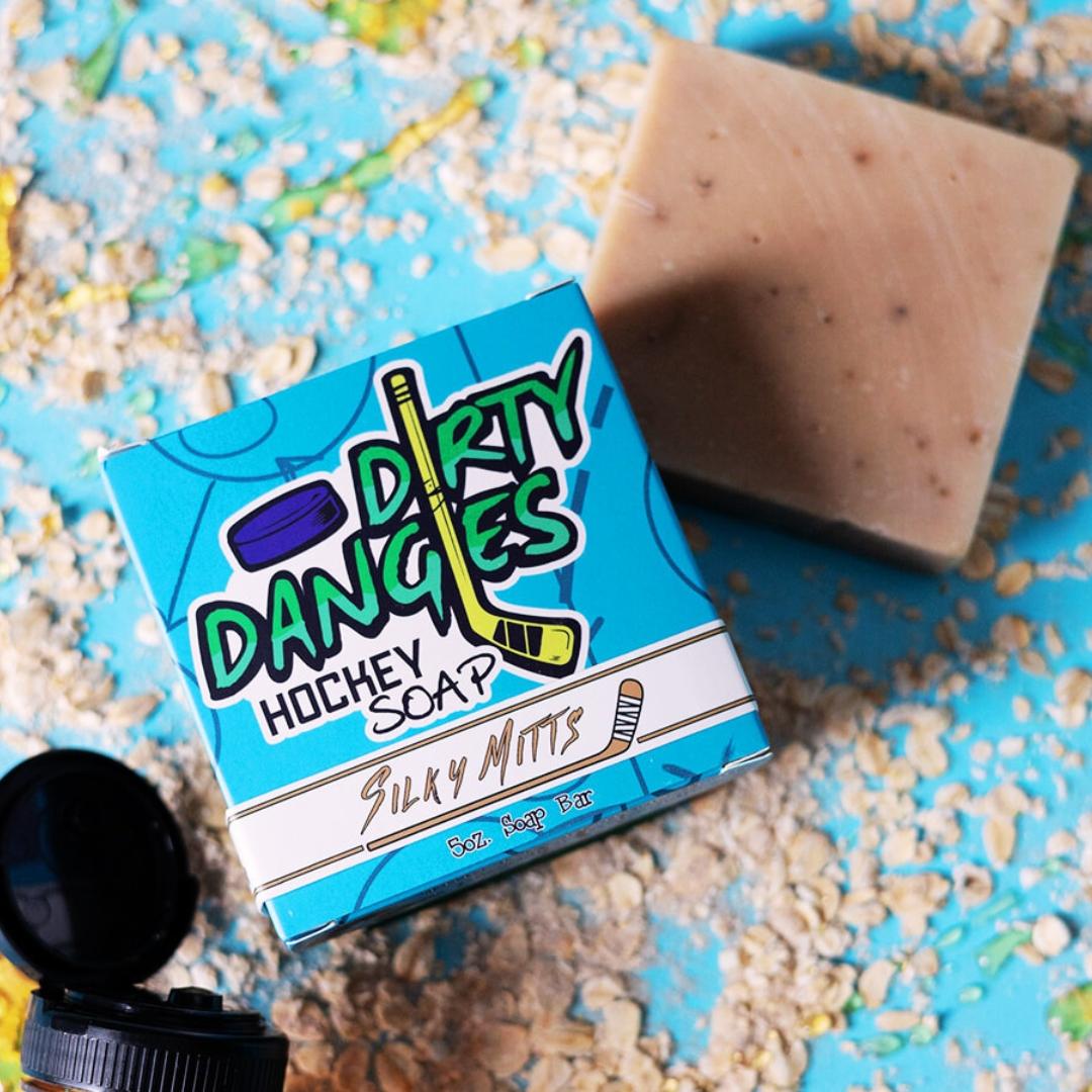 a brown silky mitts oatmeal milk and honey hockey soap bar on a blue background with honey and oats