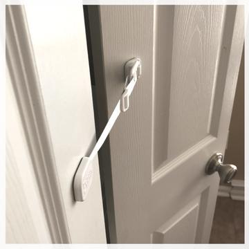 Door Buddy door strap mounted on a bi-fold door to keep the door partially open for cats while preventing larger pets or children from entering.