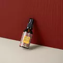 A bottle of Prinourish kept against a red corrugated background