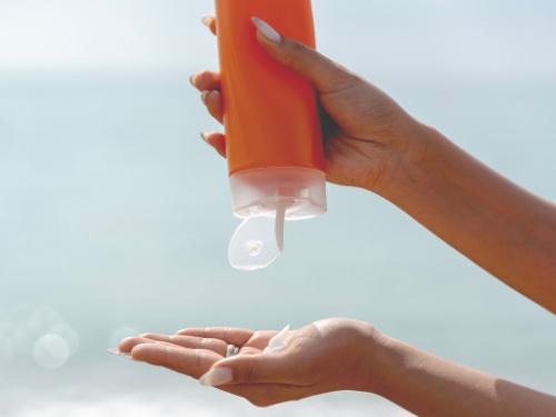 woman squeezing sunscreen into her hand.