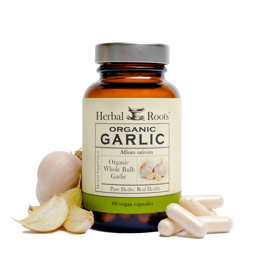 Herbal Roots Organic Garlic bottle with capsules to the right of the bottle and garlic cloves to the left of the bottle