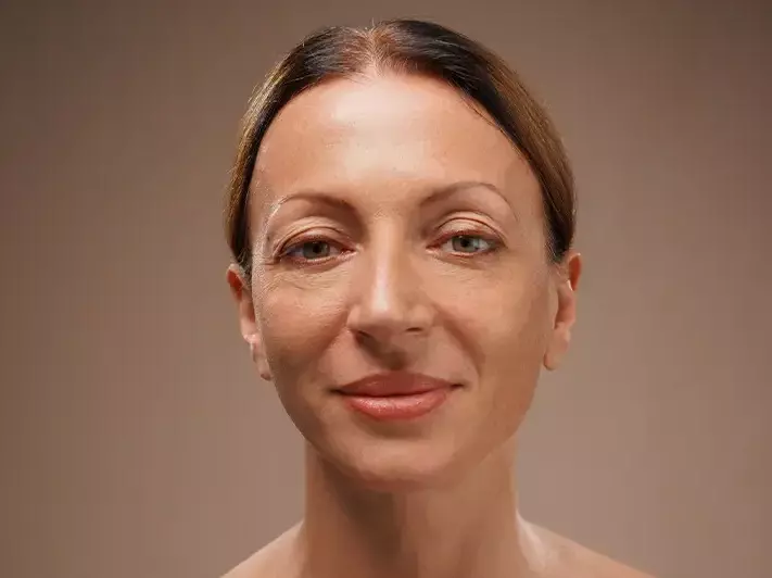 A woman with glossy finish skin, looking vibrant and youthful