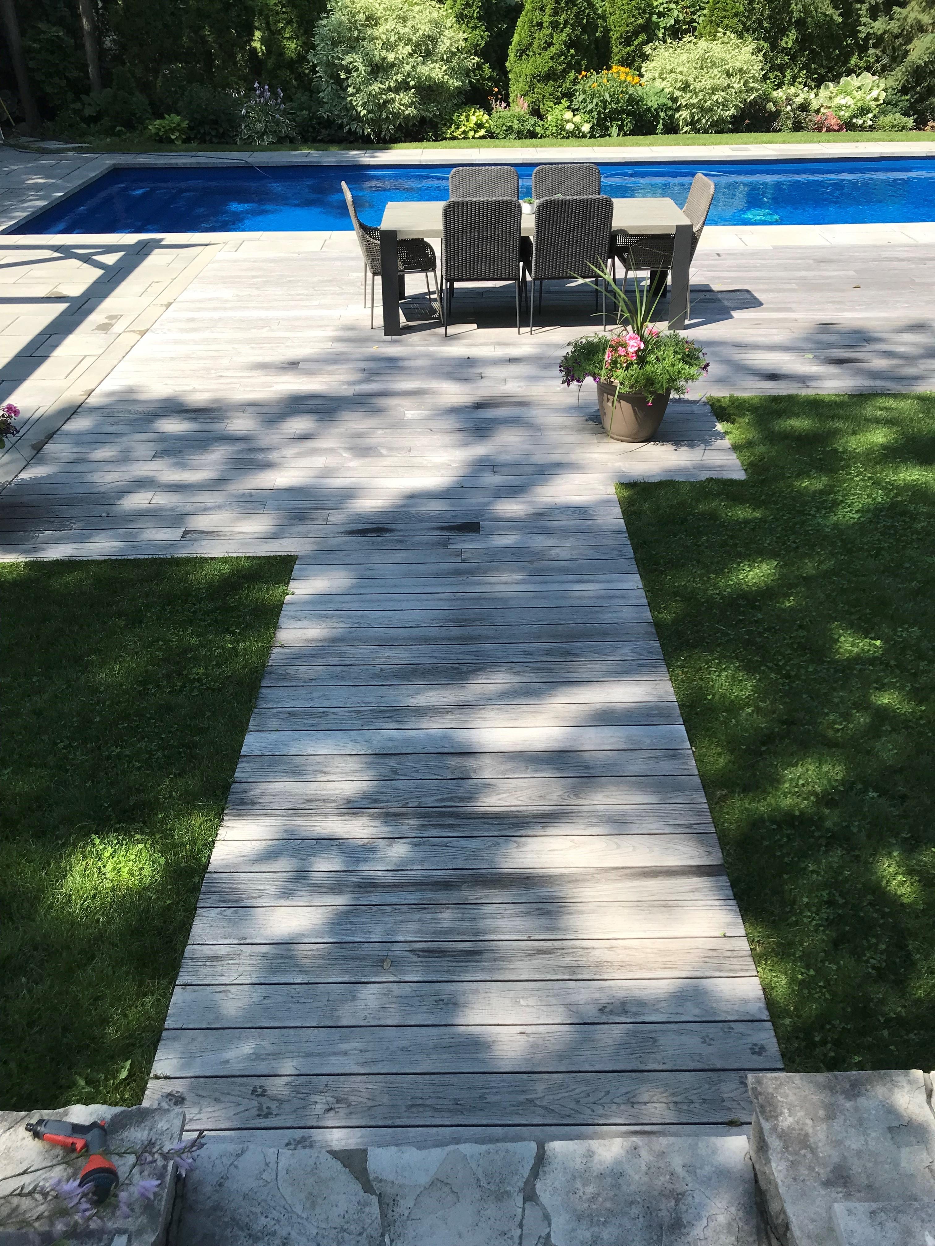 stunning faded wood boardwalk with beautiful lawn and pool in the background