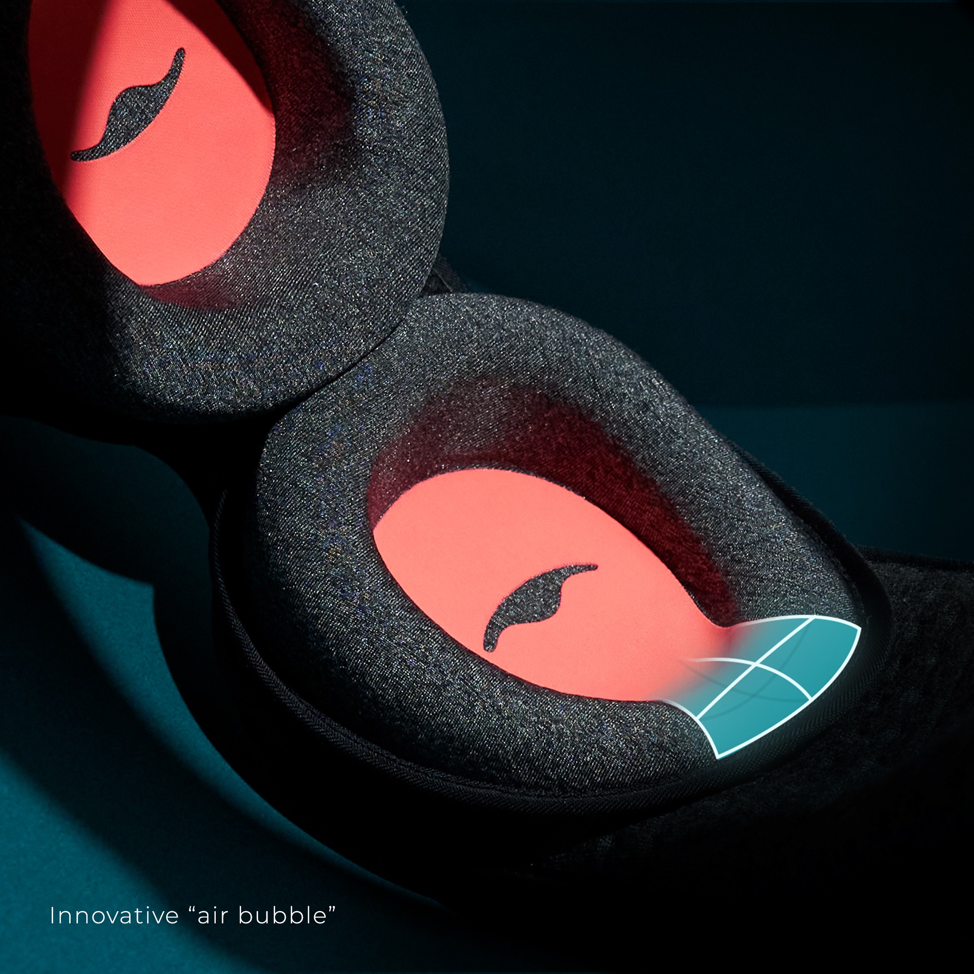 Two black and orange eye cups for a sleep mask with an air bubble.