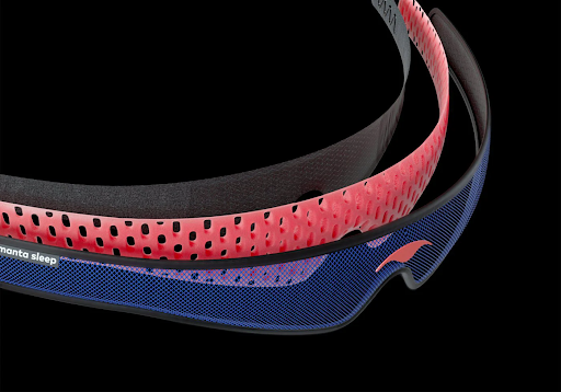 The blue, red and black layers of a head strap of a contoured sleep mask.