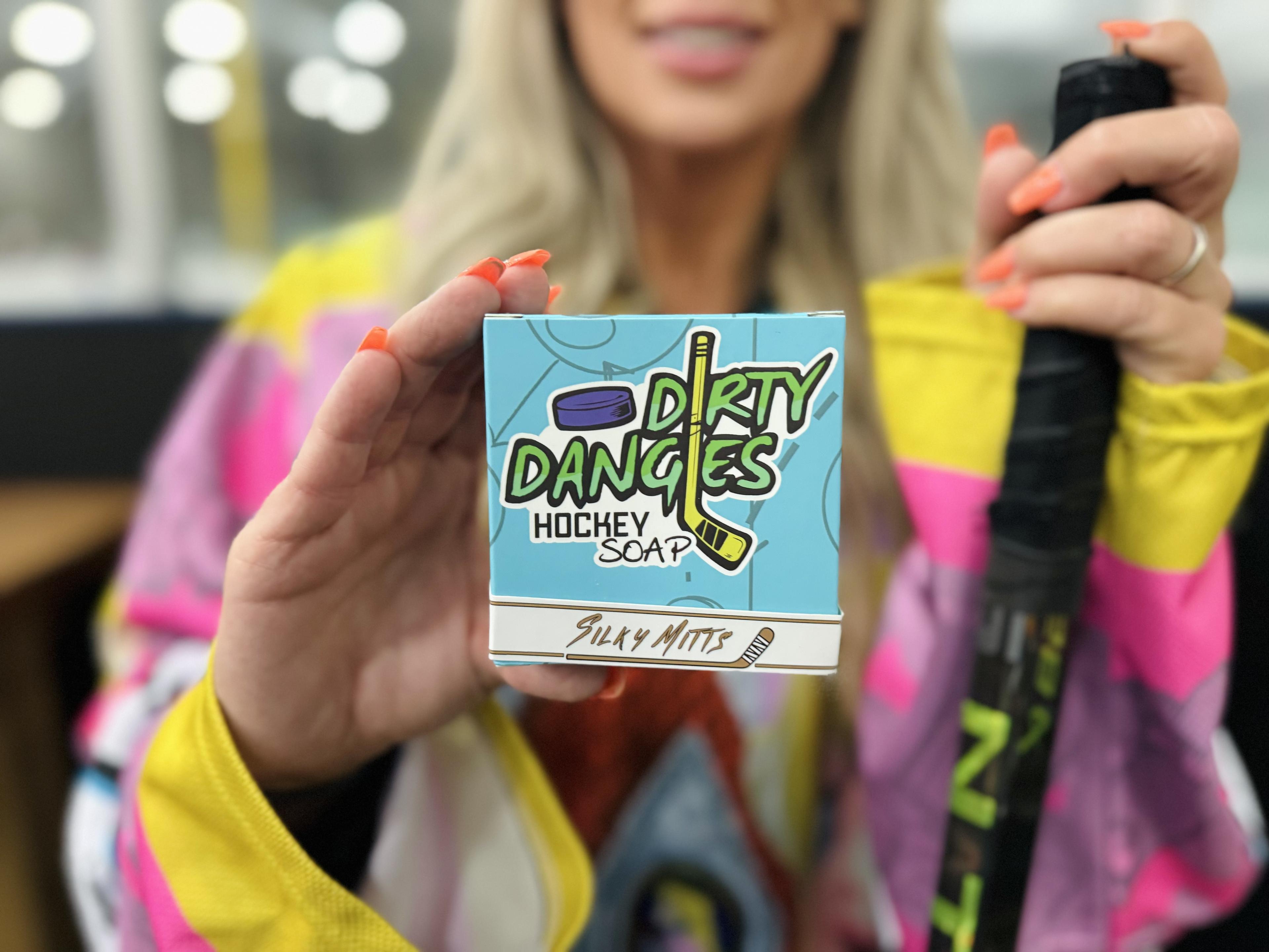 a female hockey player holding a brown silky mitts oatmeal milk and honey hockey soap bar