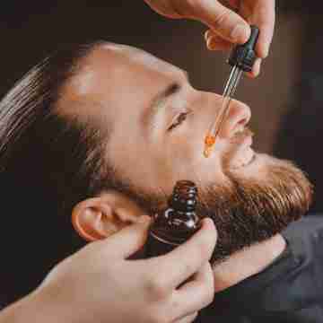 man using beard oil on beard