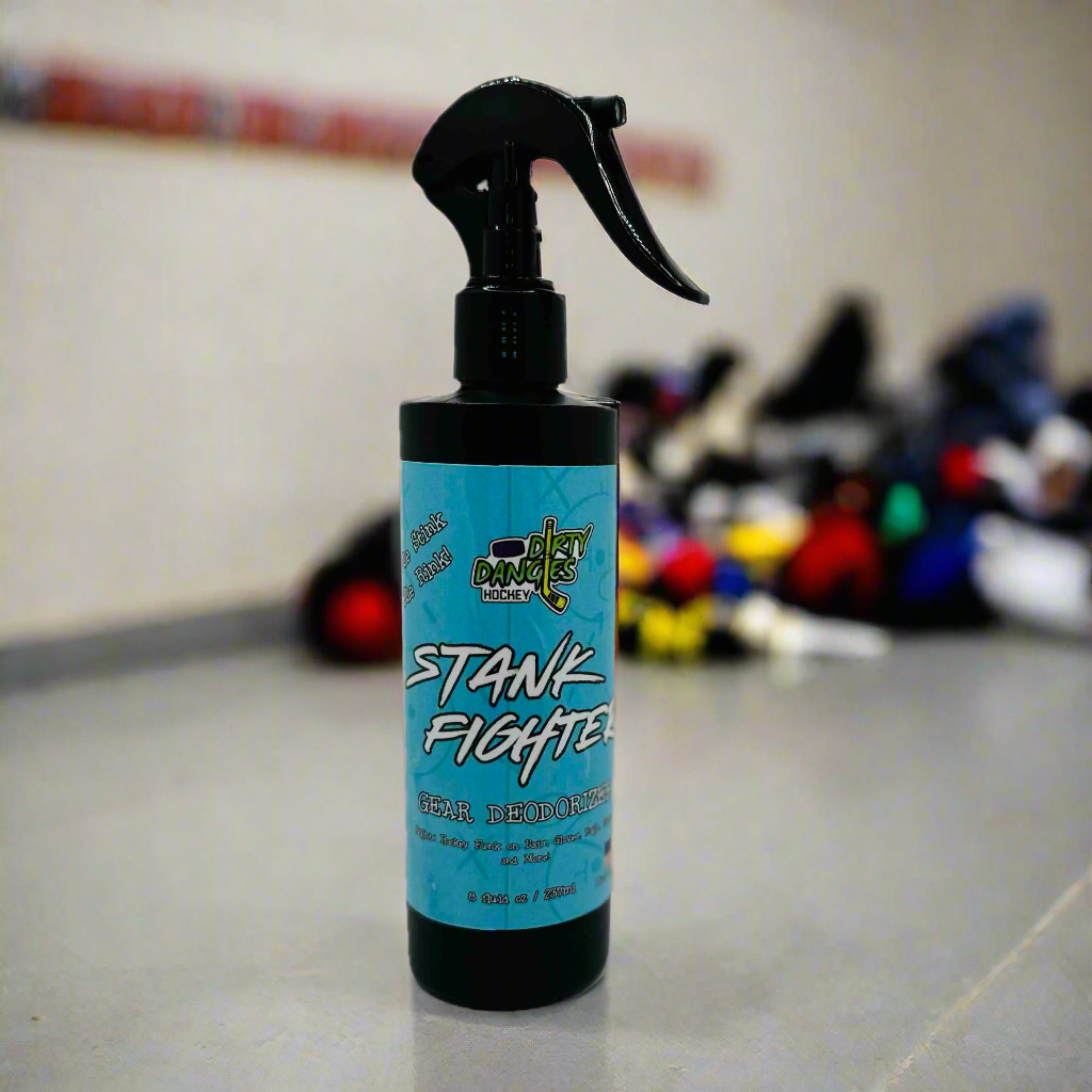 A bottle of Dirty Dangles stank fighter hockey gear deodorizer in a hockey locker room