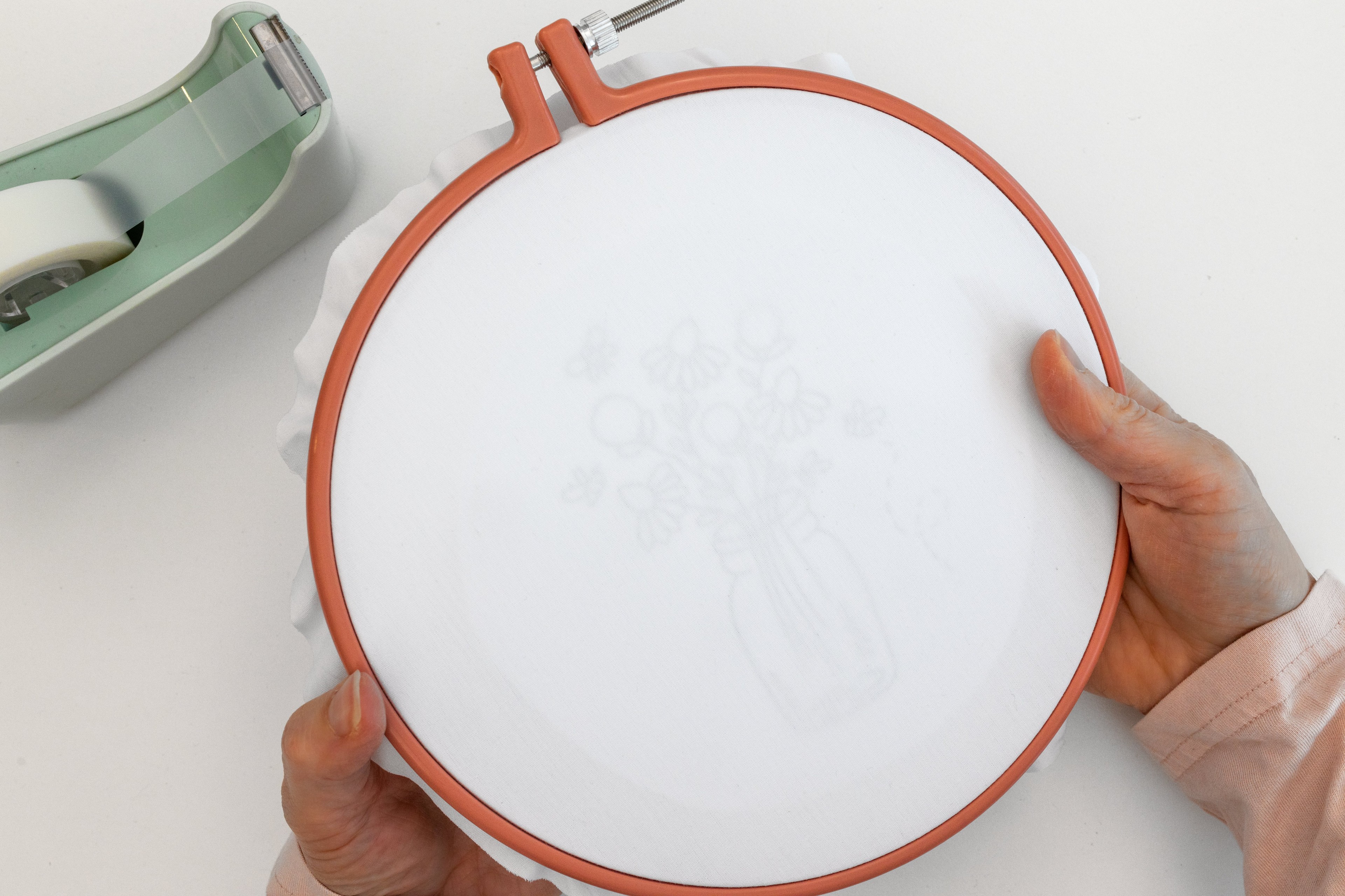 A hand holds the hoop up so you can see the pattern on the underside of the hoop.
