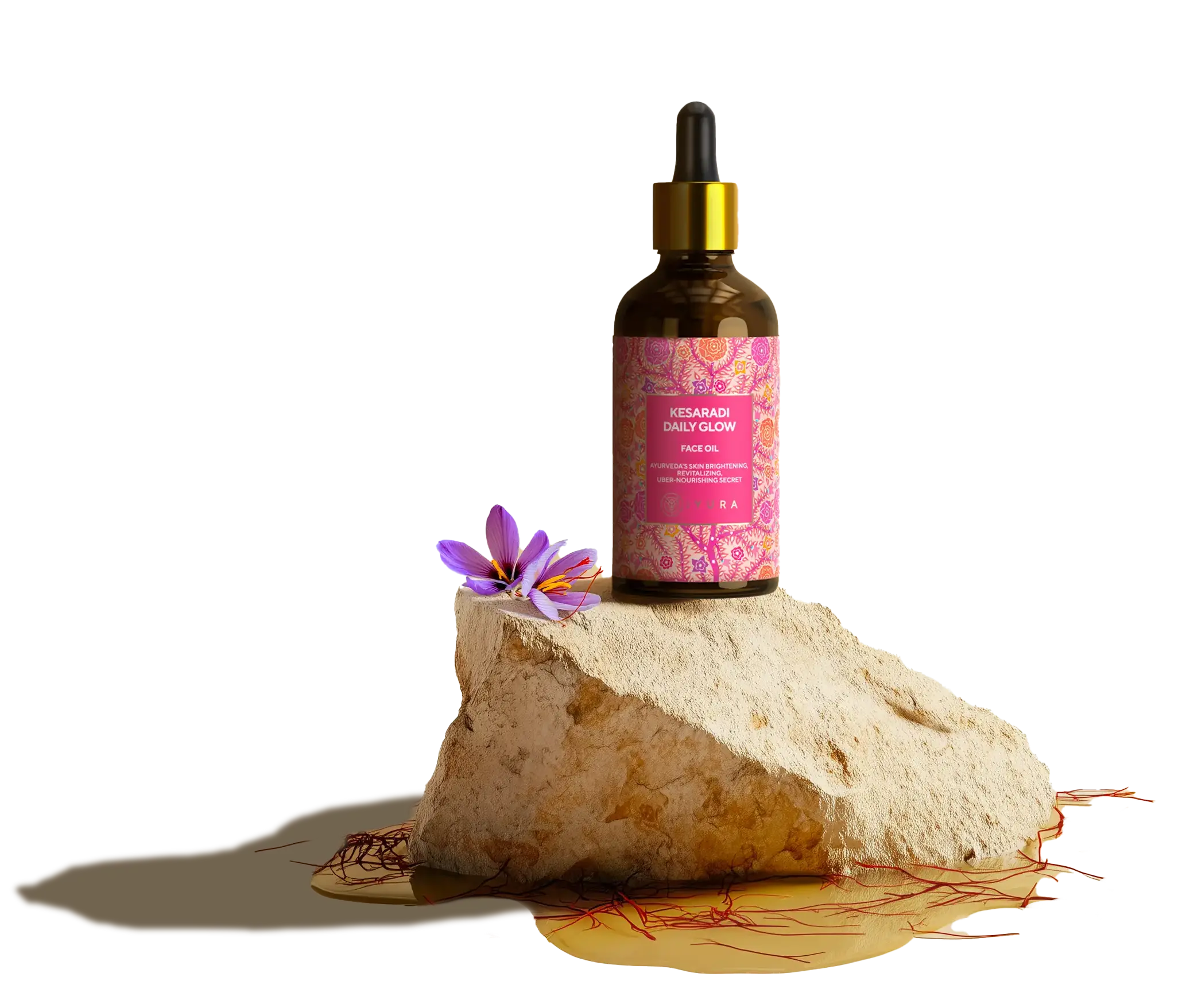 Kesaradi oil bottle kept on top of a rock with oil spilled below and saffron strands scattered