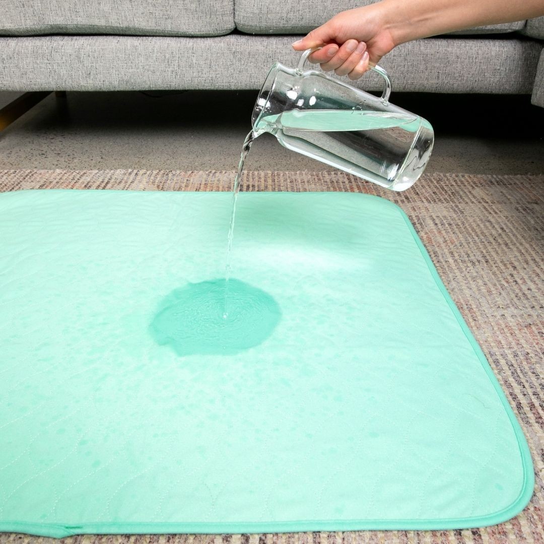 Pouring water onto reusable potty pad for dogs