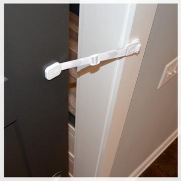 Door Buddy door strap installed on a pocket door to create a small opening that allows cats through while keeping dogs and toddlers out.