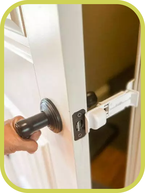 A hand turns a door knob on a door held slightly open by The Door Buddy door prop. The design allows people to easily enter the room from either side while the prop maintains a small opening for cats.