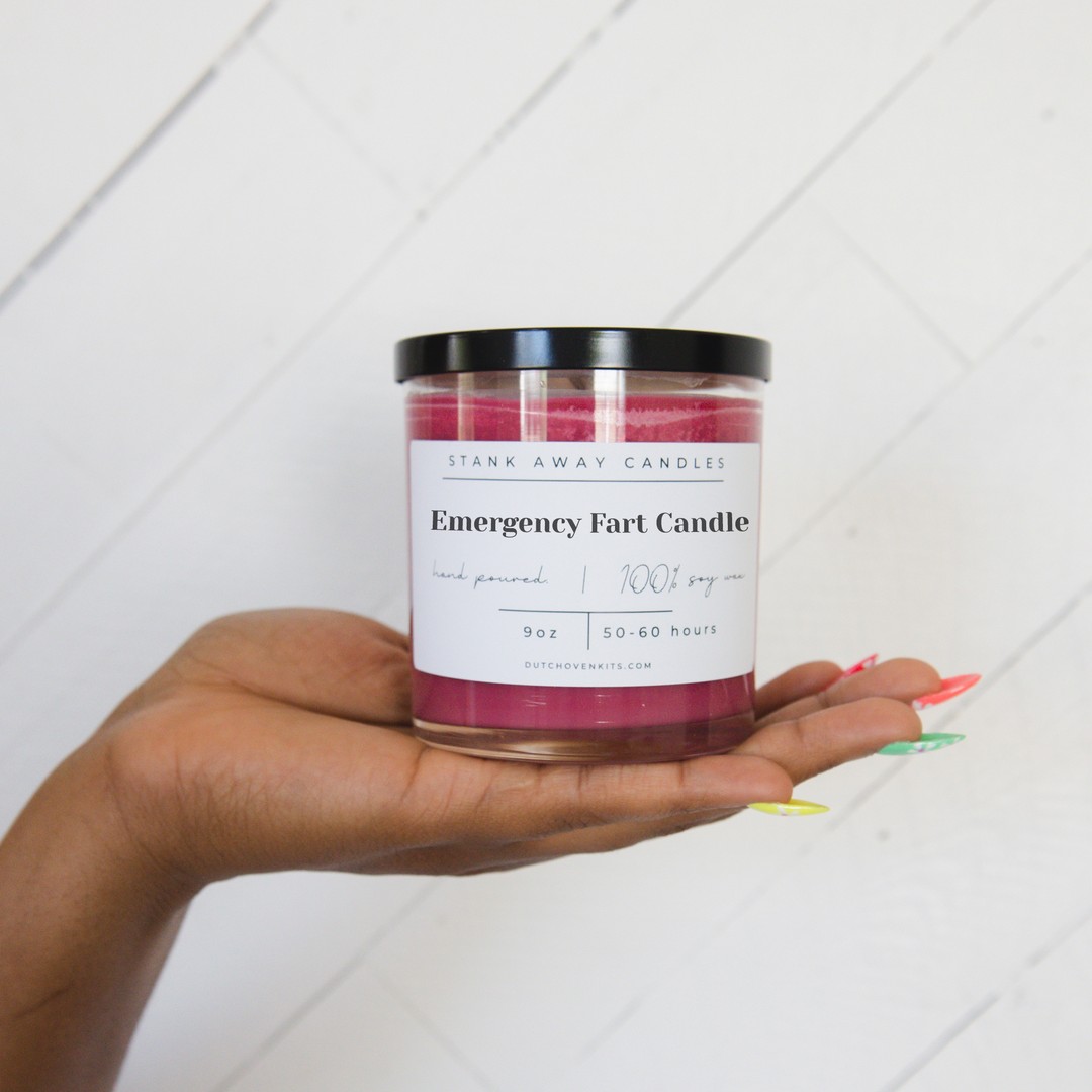 A red candle in the hand of a woman. Emergency fart candle