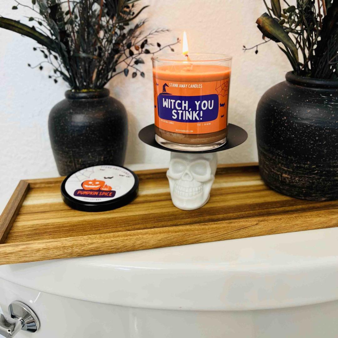 An orange witch you stink stank away halloween candle on a spooky halloween background